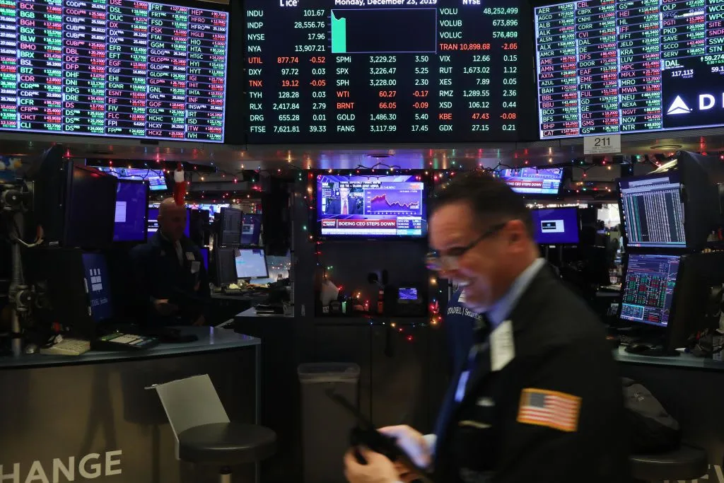 Stock exchange trading floor showcasing real-time stock market data and multiple screens with dynamic charts and prices