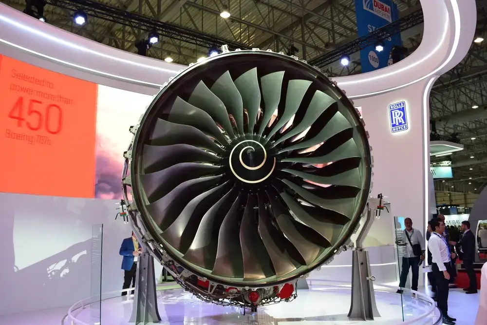 Front view of a Rolls-Royce aircraft gas turbine engine displayed at an aviation exhibition, showcasing engineering innovation 