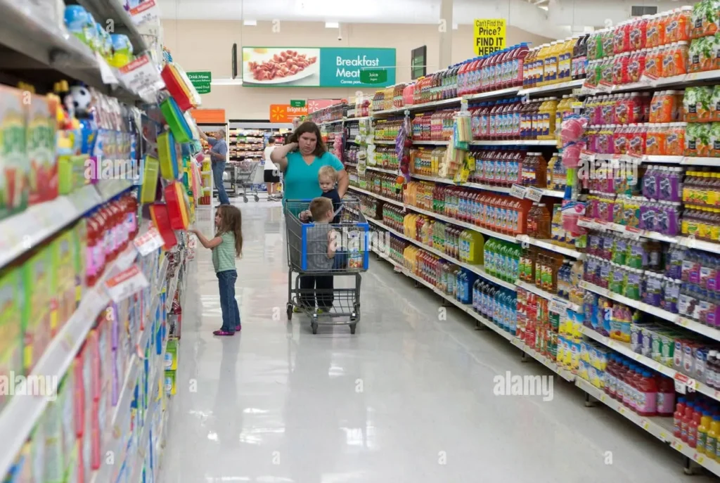 A vibrant Walmart grocery aisle with stocked shelves and shoppers including a child reaching for items and a woman pushing a cart with children
