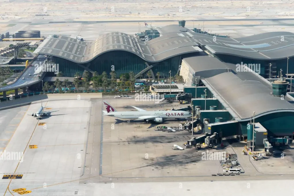 Aerial view of Doha Hamad International Airport terminal showcasing Qatar Airways aircraft at the gate 