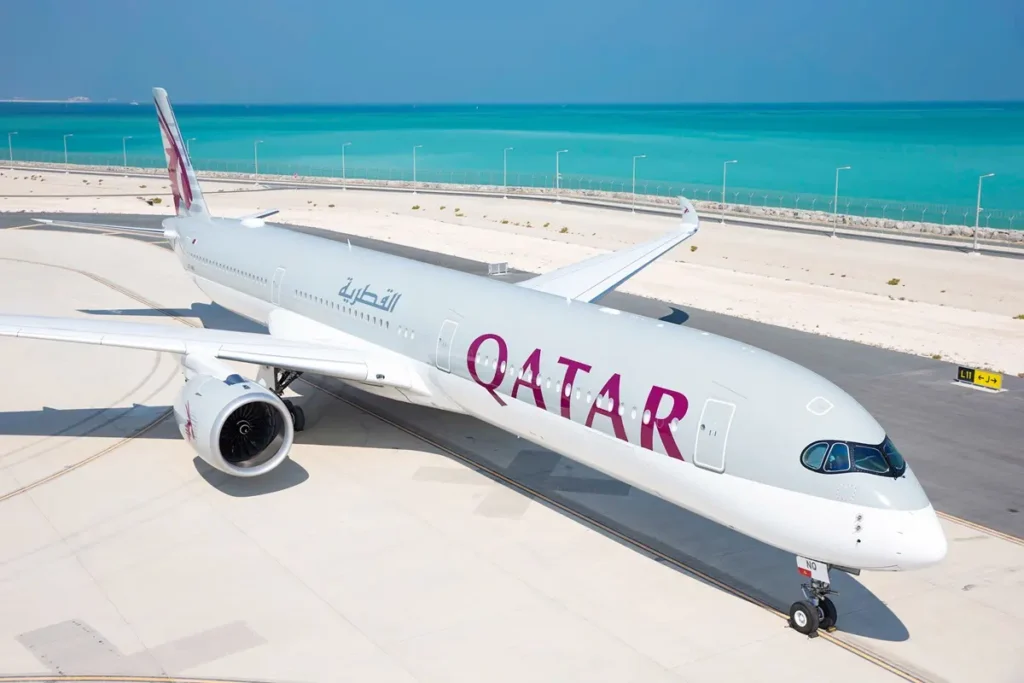 A modern Qatar Airways Airbus A350 aircraft on the tarmac near the sea, highlighting the airline's advanced fleet 
