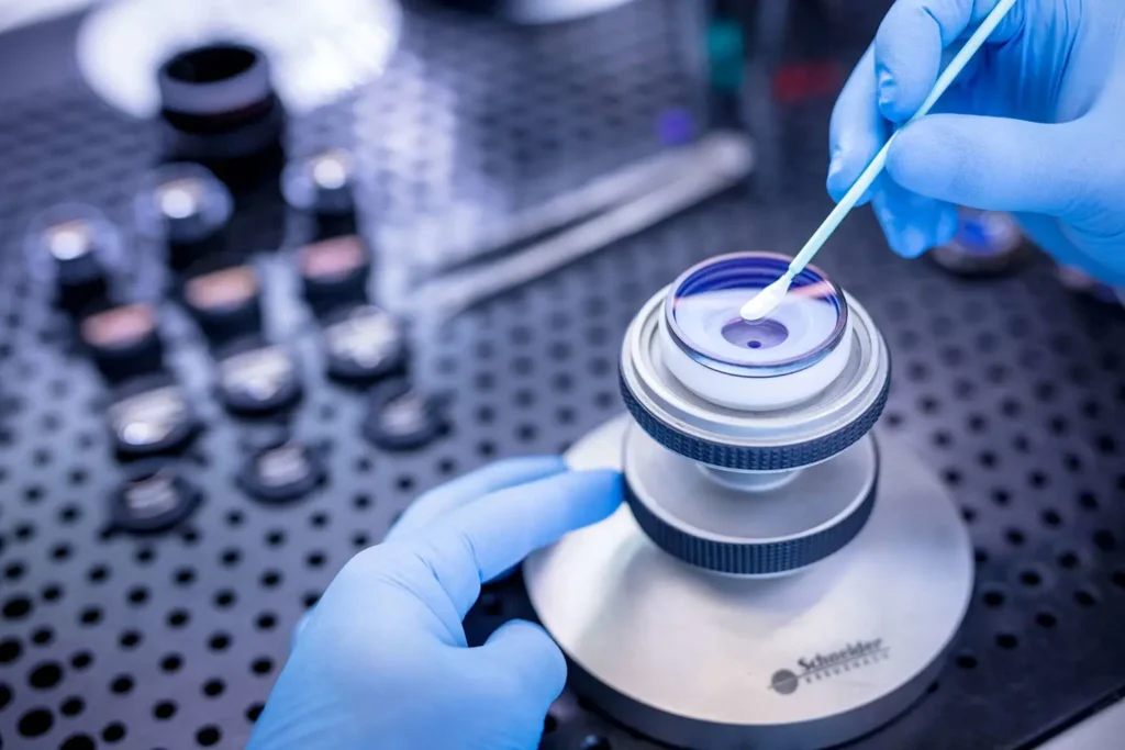 Precision manufacturing of optical lenses in a clean room environment, highlighting the meticulous process involved in defense optics production 