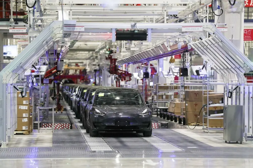 Tesla Model Y electric vehicles on the production line in a modern Tesla factory, showcasing the scale and automation of Tesla's manufacturing process 