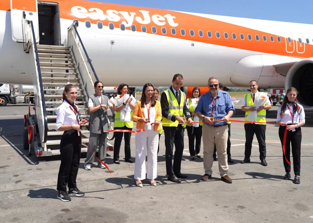 EasyJet staff and officials at a ceremonial event in front of an EasyJet airplane at Tirana International Airport 
