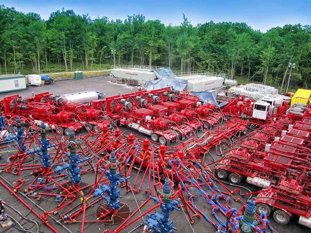Hydraulic fracturing equipment and Halliburton storage tanks at an oilfield site illustrating advanced fracking technology 